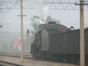 駅構内を運行中の煙を吐く蒸気機関車（SL）